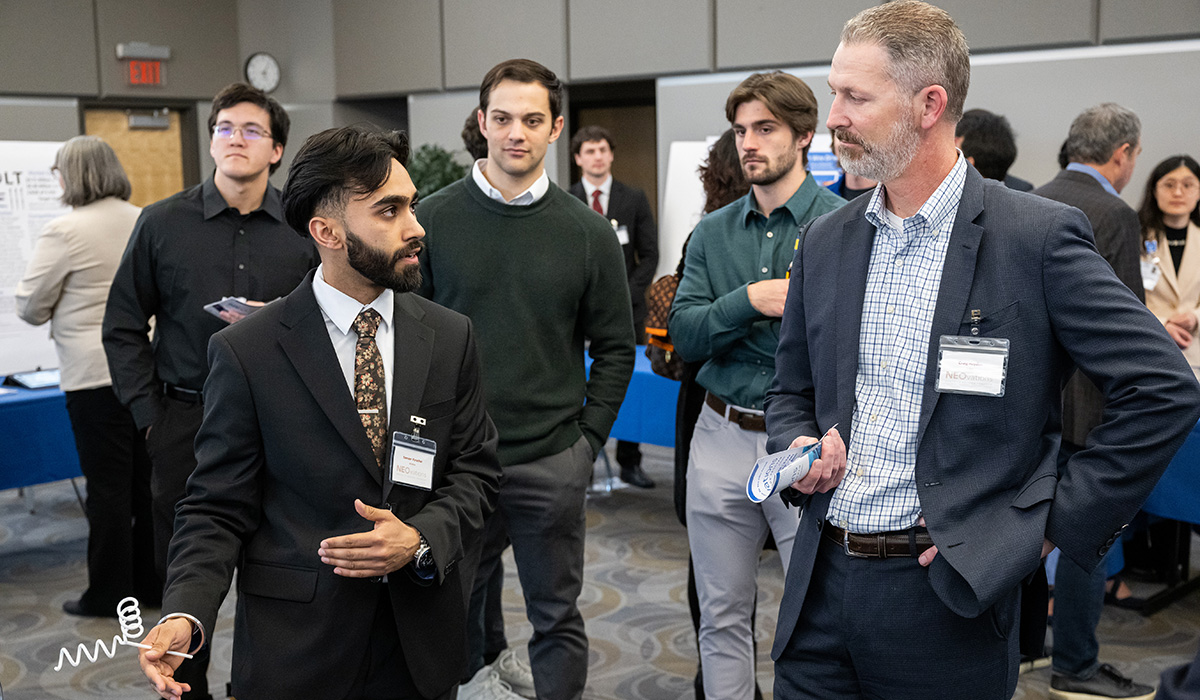Young man in suit explains a product to a competition judge.