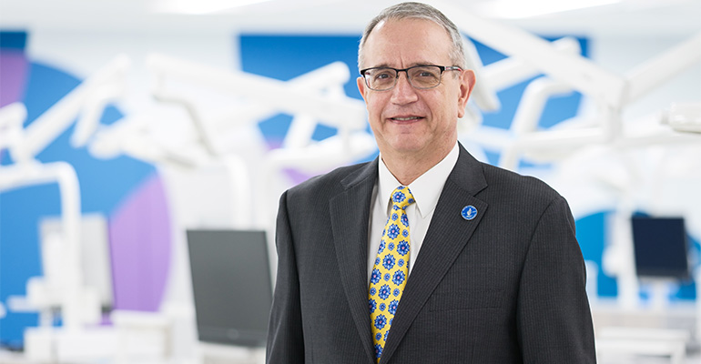 Sorin Teich poses in colorful dental simulation lab