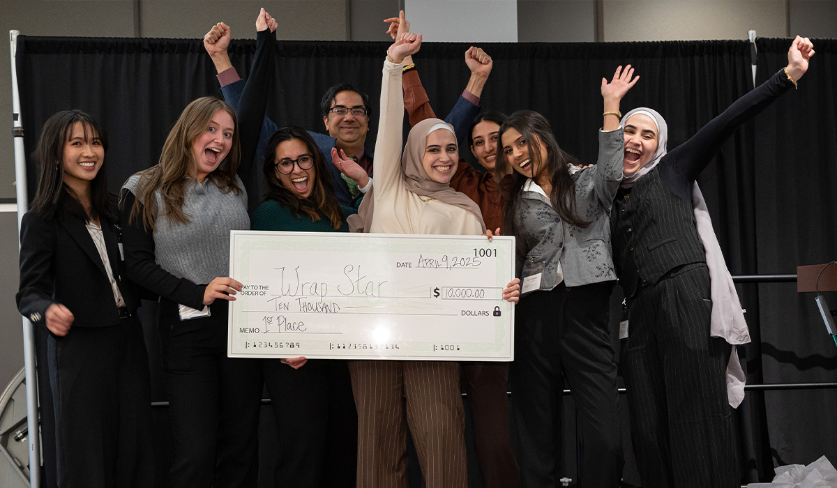 Happy group of young women celebrate receiving an oversized check