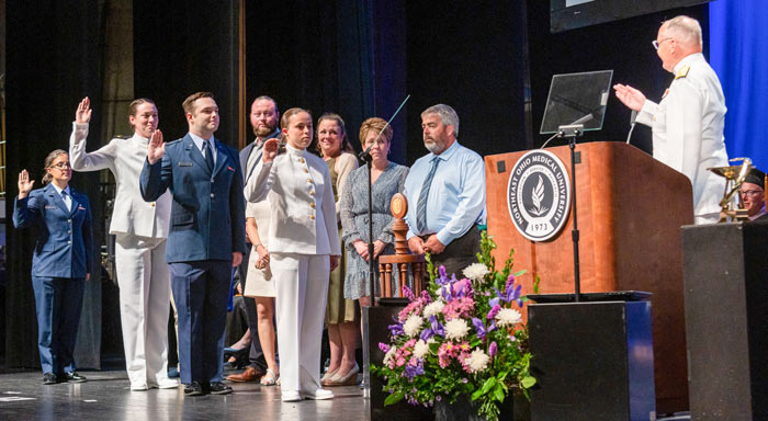 During commencement, four graduates in military dress are commissioned.