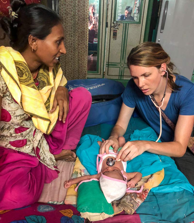 A student physician checks on a newborn.