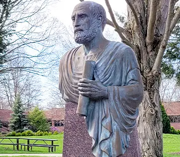 A statue of Hippocrates in a courtyard on the NEOMED campus.