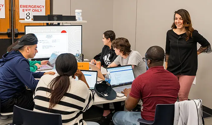 institute-for-teaching-excellence-600 A faculty member talks with students seated around a table as the students work on a problem together.