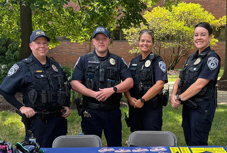 Four NEOMED officers in uniform at a campus picnic.