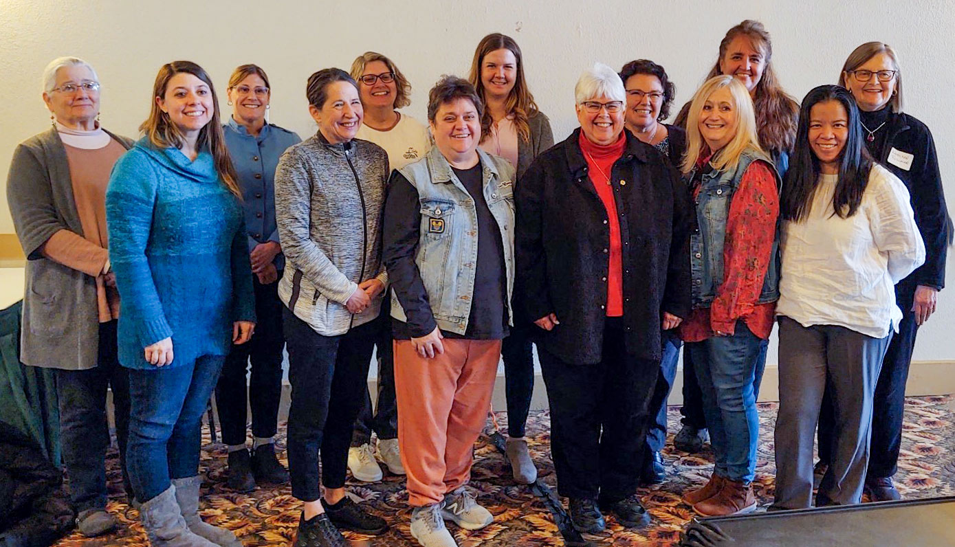 A group of women stand shoulder to shoulder