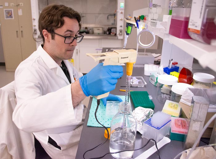 A researcher in a white coat works in the Reed Lab at NEOMED.