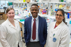 Three researchers stand in a bright, modern pharmaceutical sciences lab at NEOMED