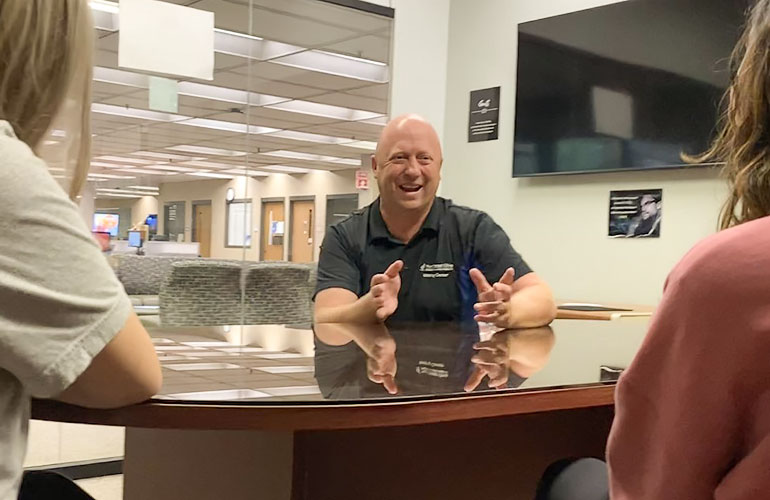 A Writing Center specialist gestures while making a recommendation to a student.